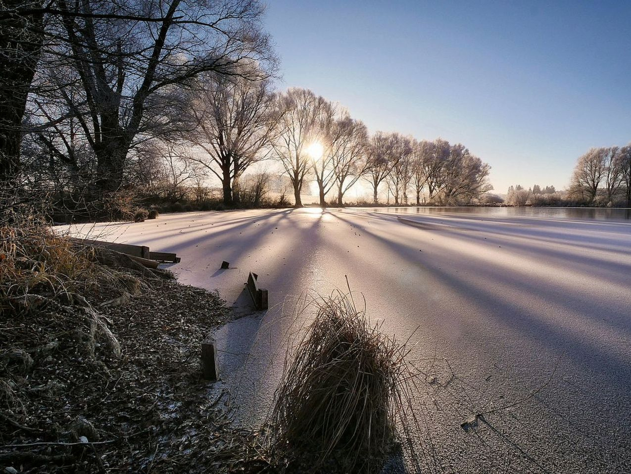 Espesor del hielo en la orilla del lago de montaña al amanecer